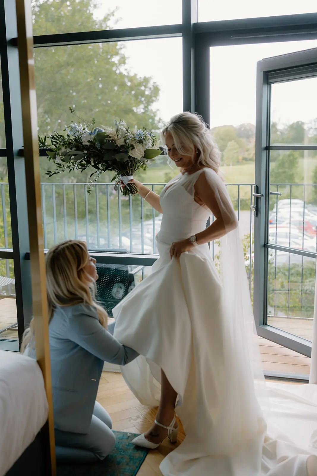 The bride having her dress arranged